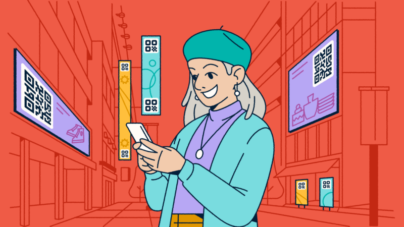 A woman standing in a city with digital advertisements featuring QR Codes around her. She's holding a smartphone in her hands.