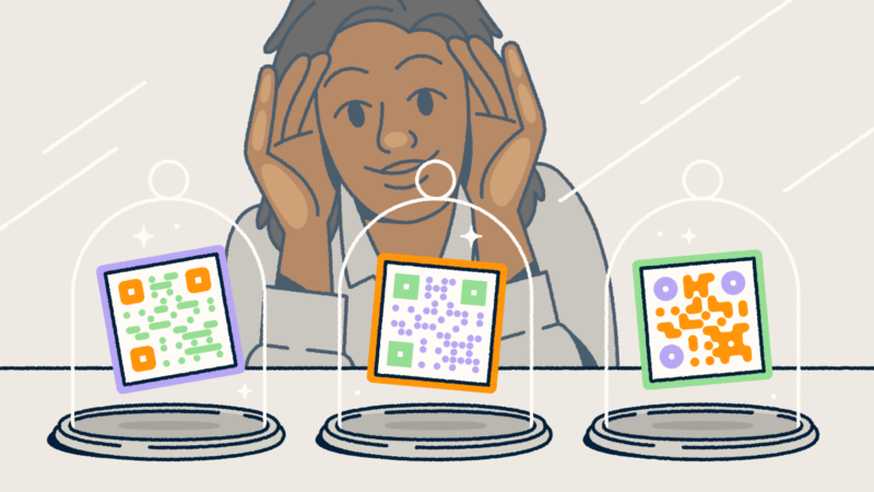 A person looking through a store-front window at three different QR codes on display in glass cloches.