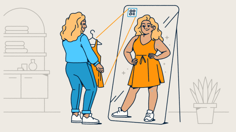 A woman in a blue outfit standing in front of a floor-length mirror with an AR QR Code on it. She's holding an orange dress that's from the QR Code, and her reflection shows her in the dress.