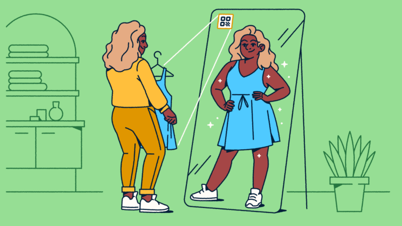 A woman in an orange outfit standing in front of a floor-length mirror with an AR QR Code on it. She's holding a blue dress that's from the QR Code, and her reflection shows her in the dress.